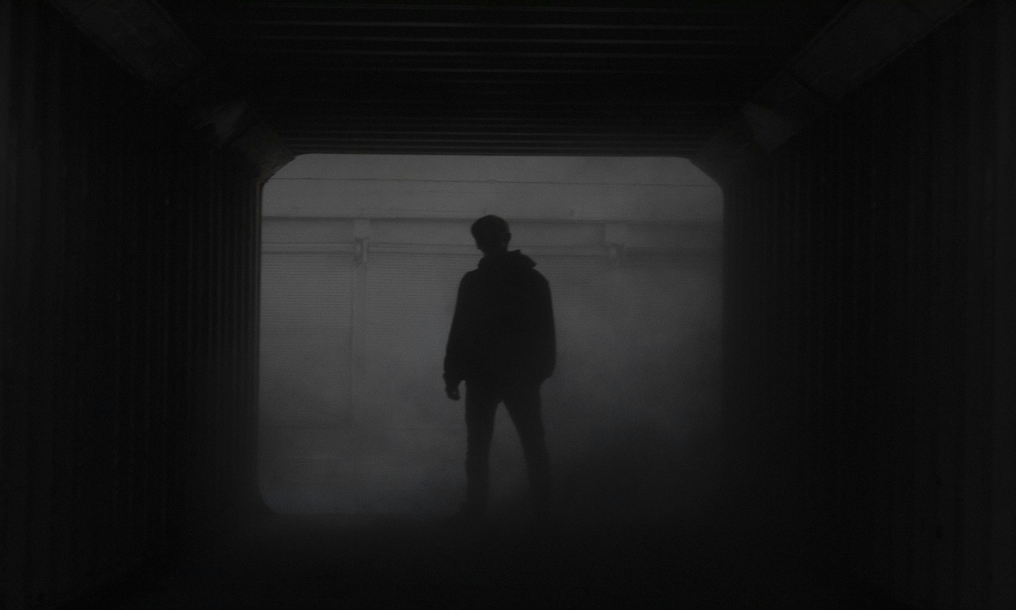 Silhouette of a man standing in front of a window