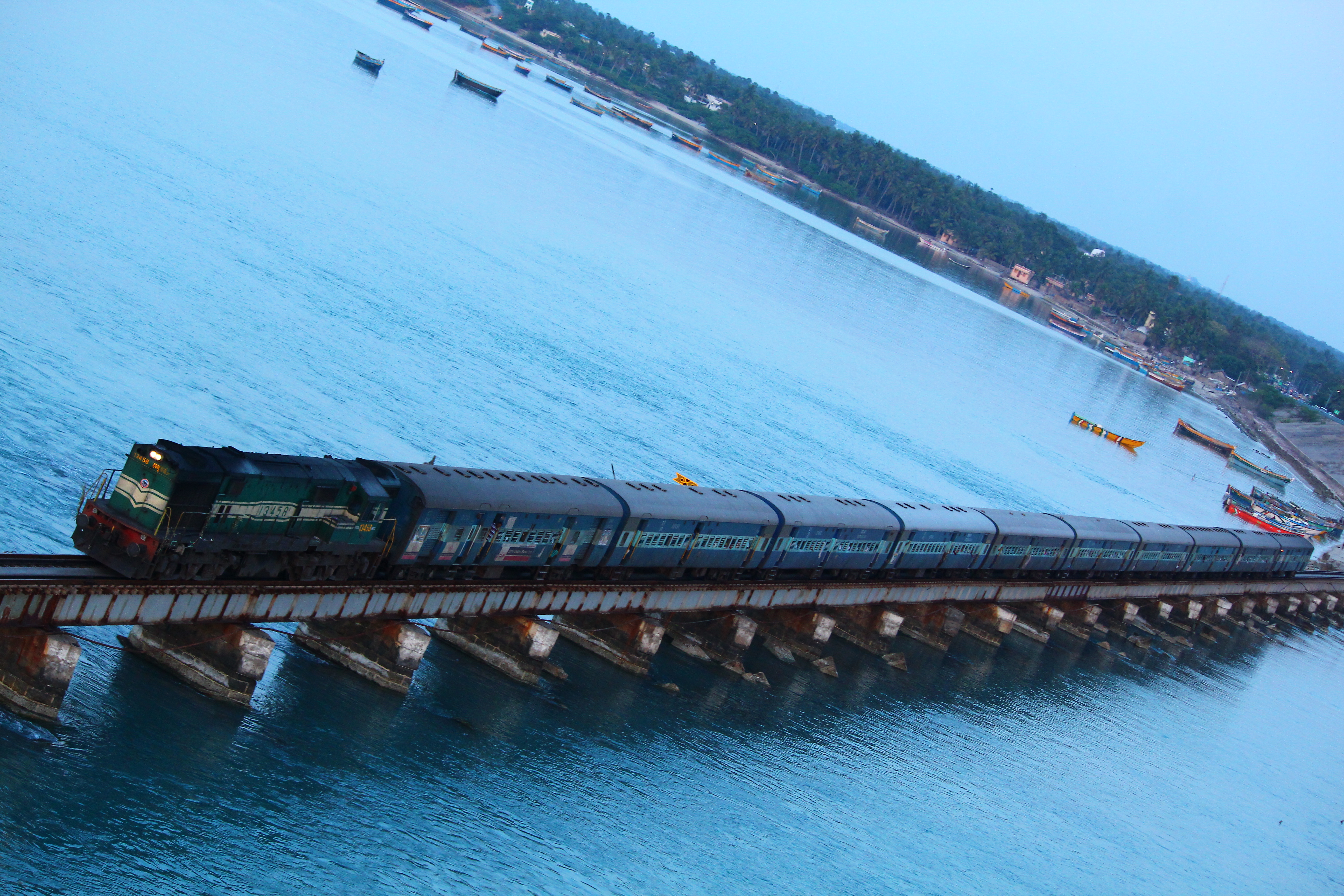 A passenger train crosses Pamban Bridge above the sea