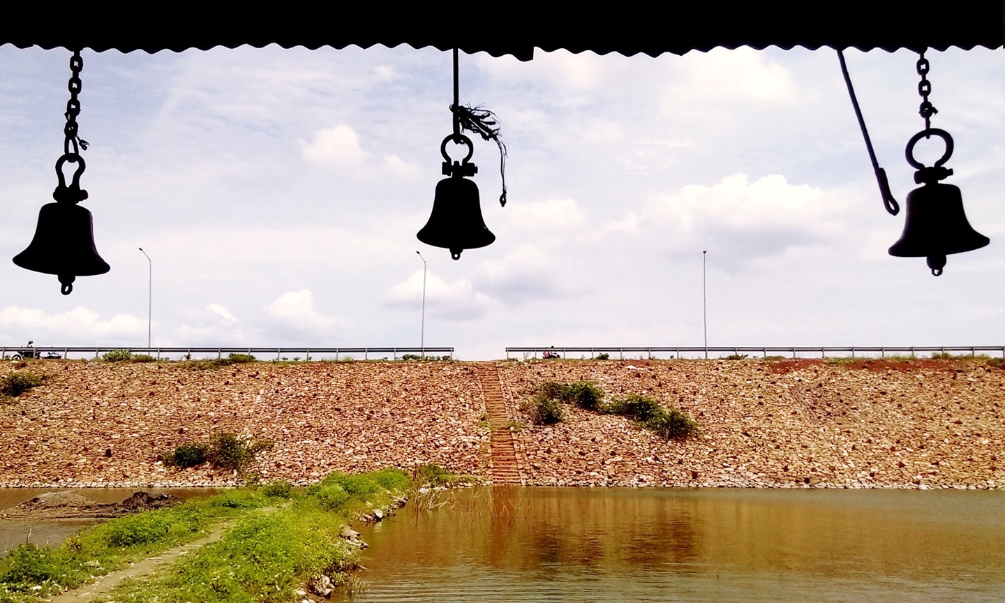 Temple bells silhouetted against a cloudy sky
